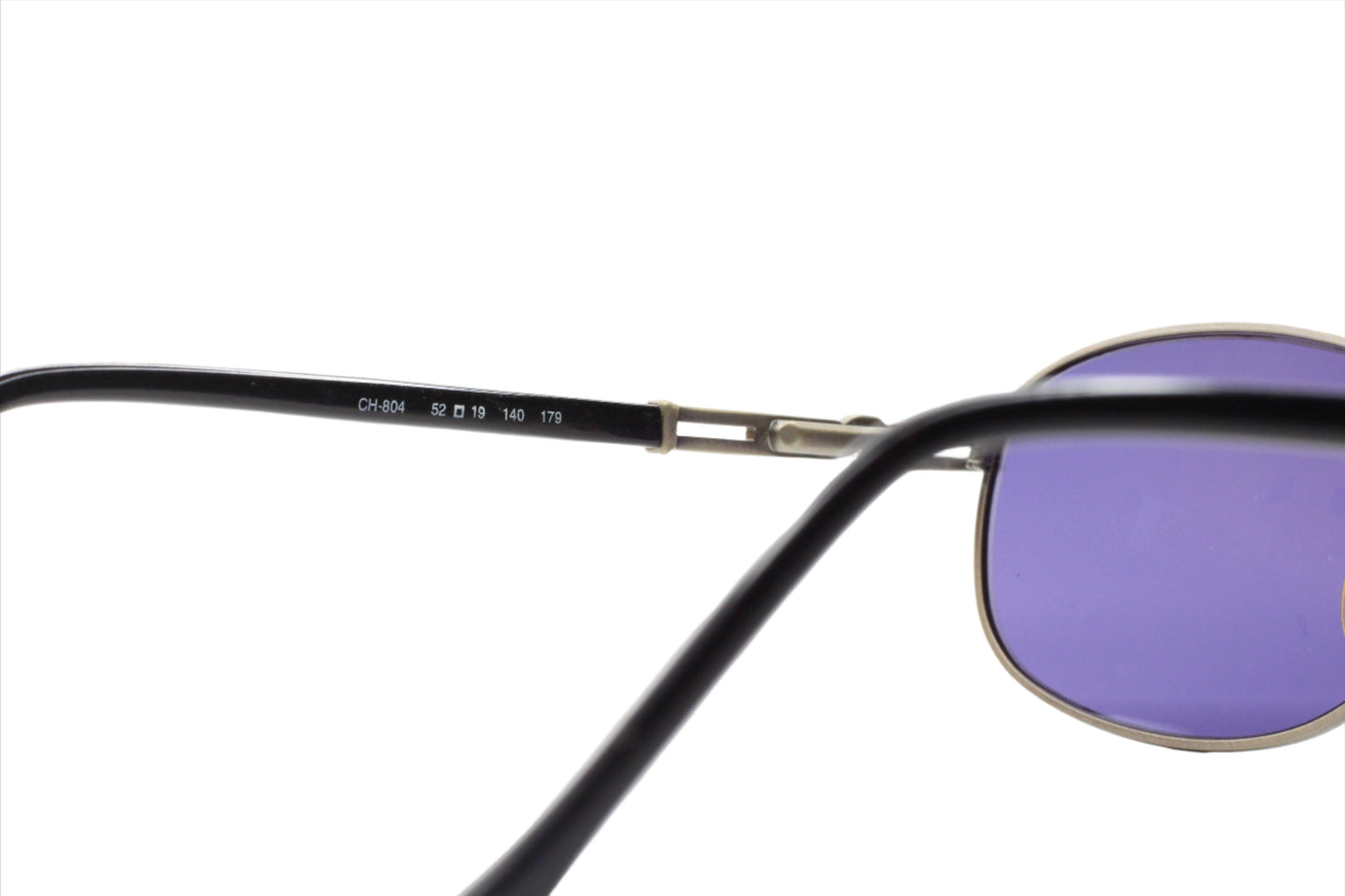 Close-up of CH804 PD520 Carolina Herrera sunglasses frame with purple lenses by ABC Optical