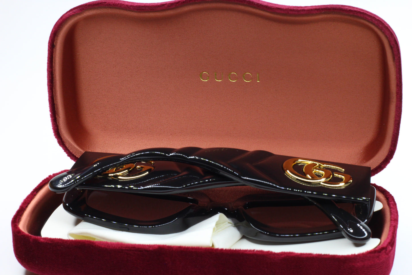Gucci GG0811S sunglasses in black with gold logo detail in a red velvet case by ABC Optical