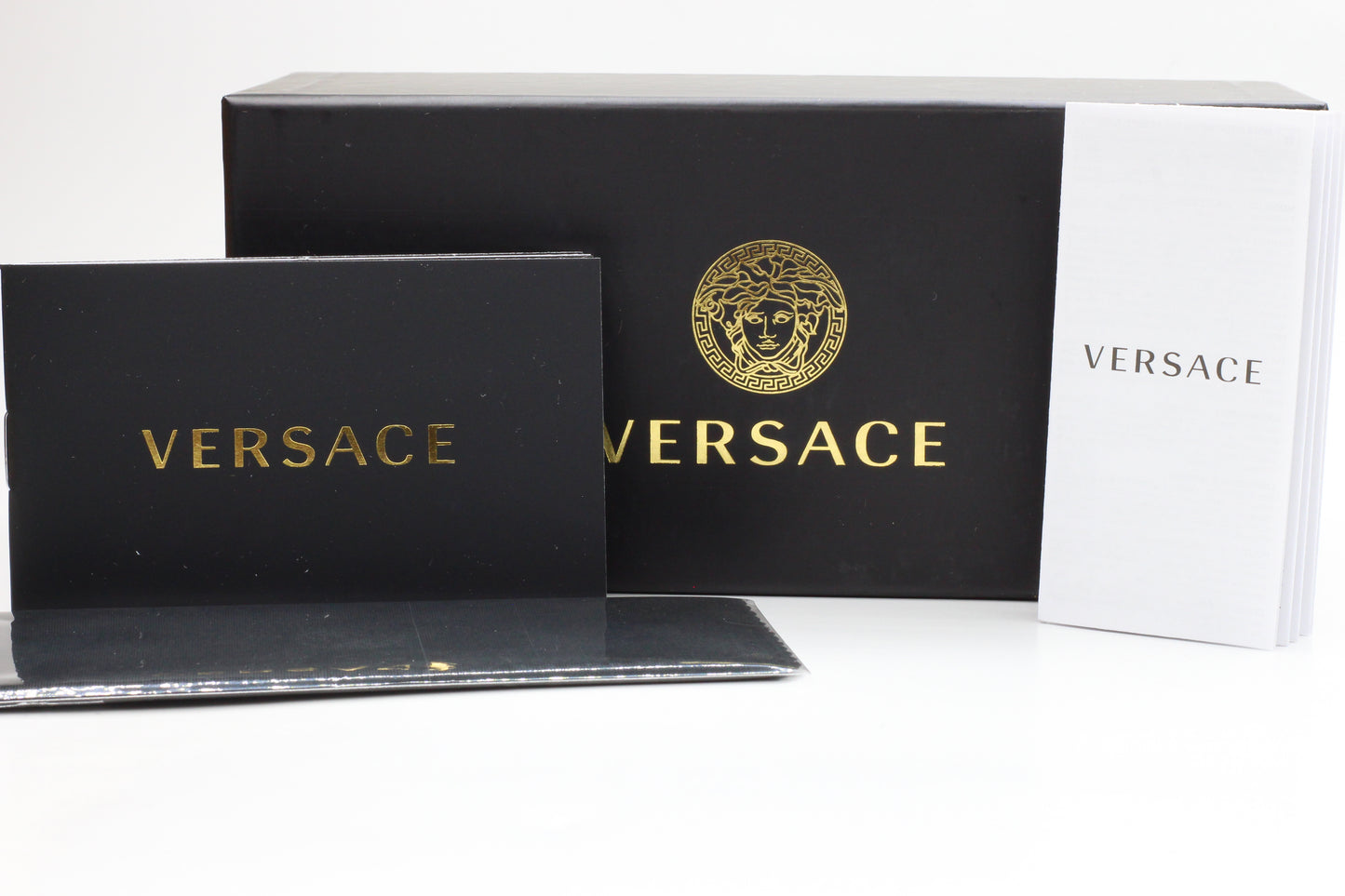 Versace optical frames packaging set with black and white boxes showcasing luxury design and logo to buy authentic Versace eyewear online