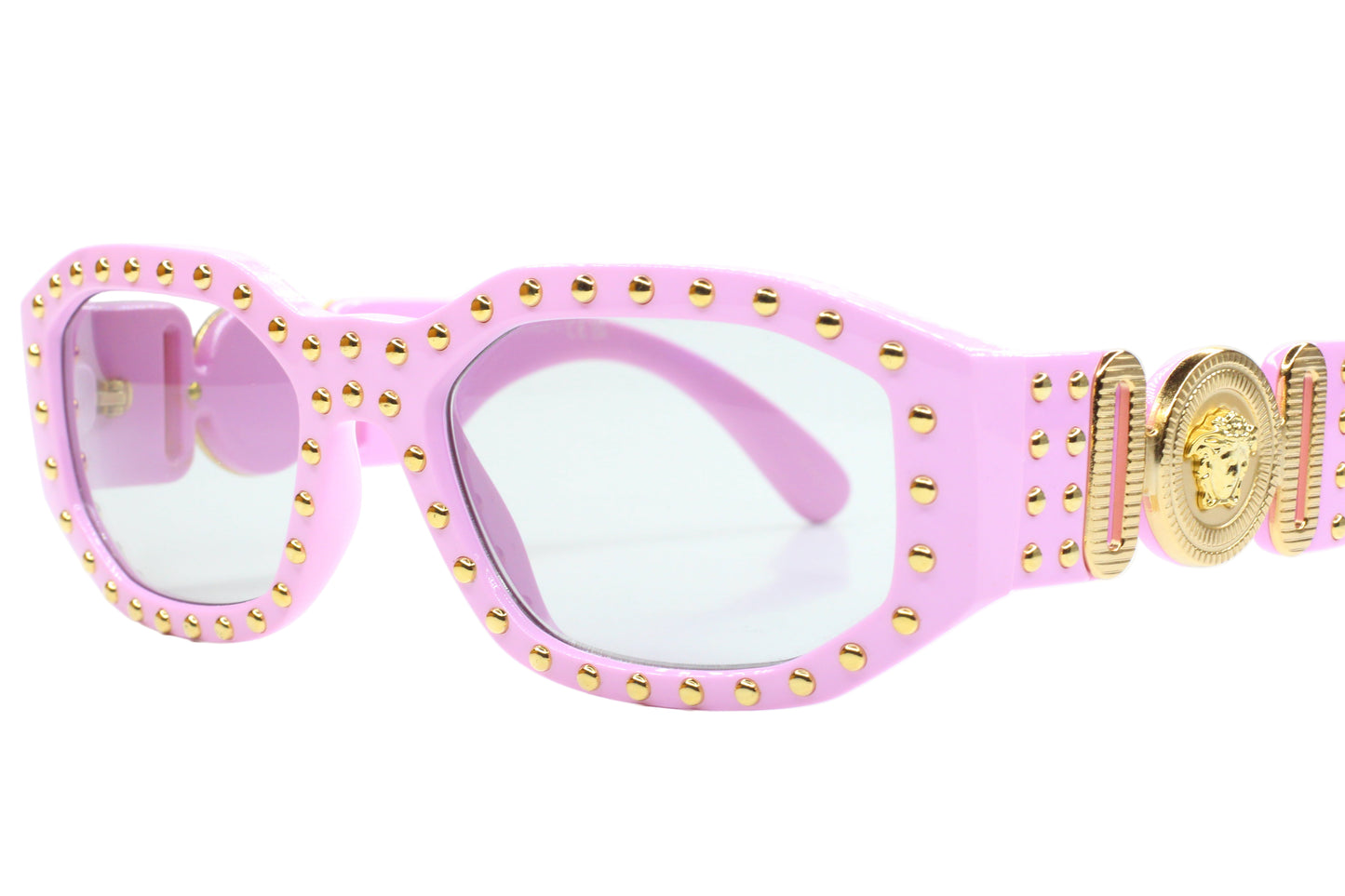 Pink sunglasses with gold accents on a white background