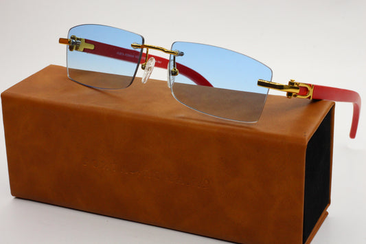 Sunglasses with red arms on a brown leather case against a white background