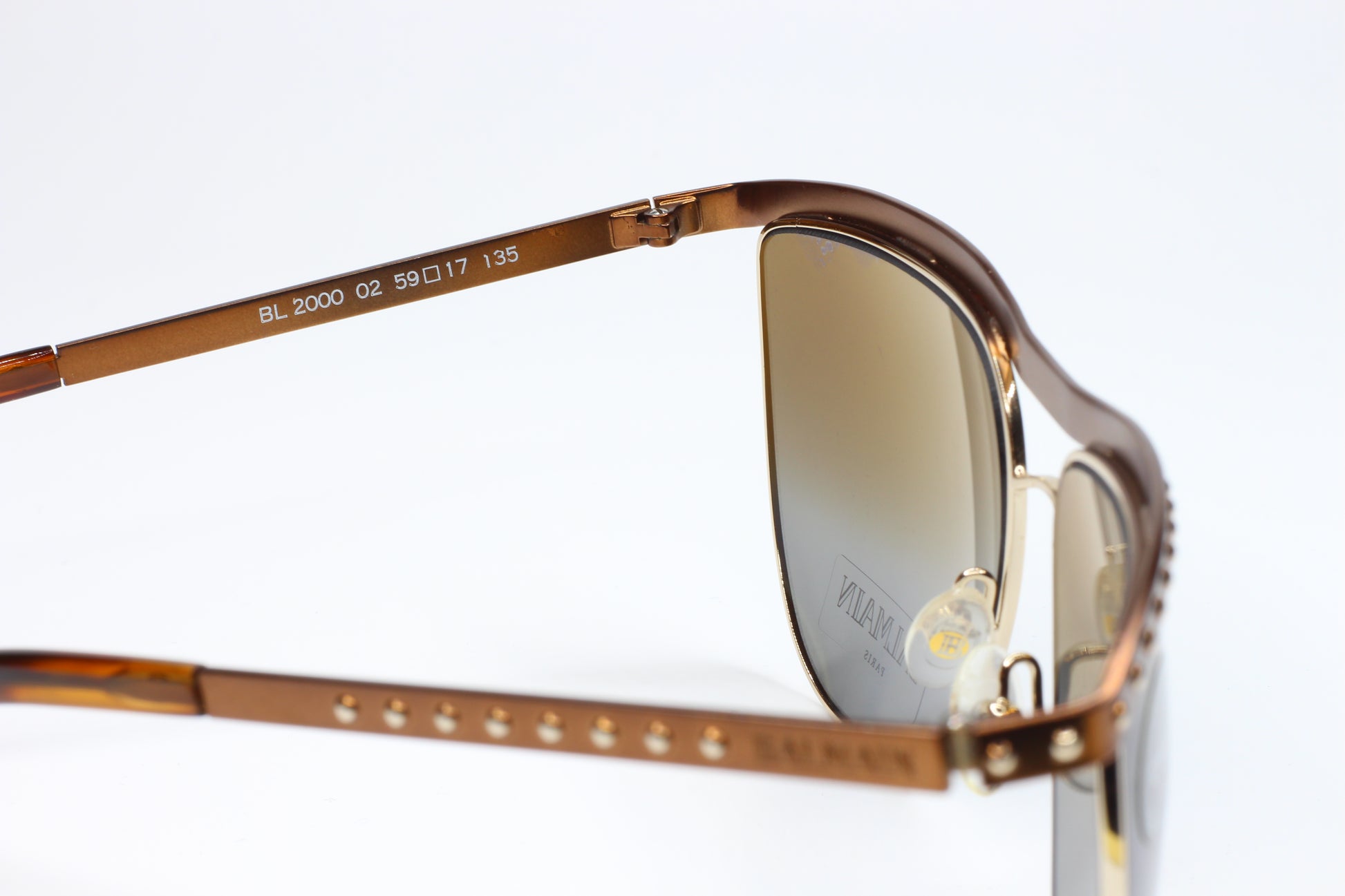 Close-up of Balmain BL2000 02 sunglasses for sale with brown frame and gold accents by ABC Optical