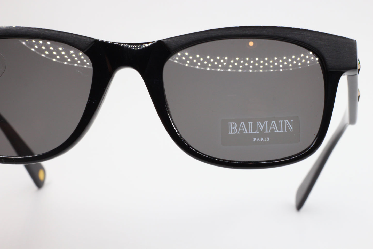 Close-up of Balmain BL4002 sunglasses by ABC Optical with black rectangular frames and gray lenses