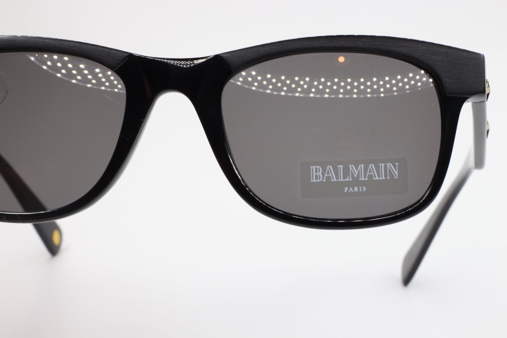 Close-up of Balmain BL4002 sunglasses by ABC Optical with black rectangular frames and gray lenses