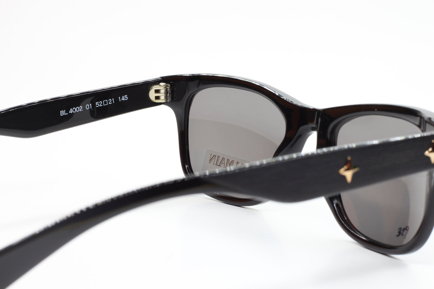 Close-up of Balmain BL4002 sunglasses with black frames and gray lenses by ABC Optical
