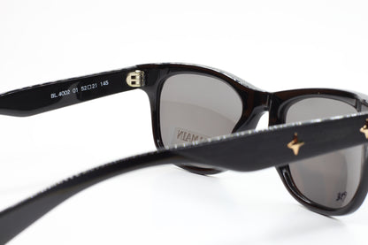 Close-up of Balmain BL4002 sunglasses with black frames and gray lenses by ABC Optical