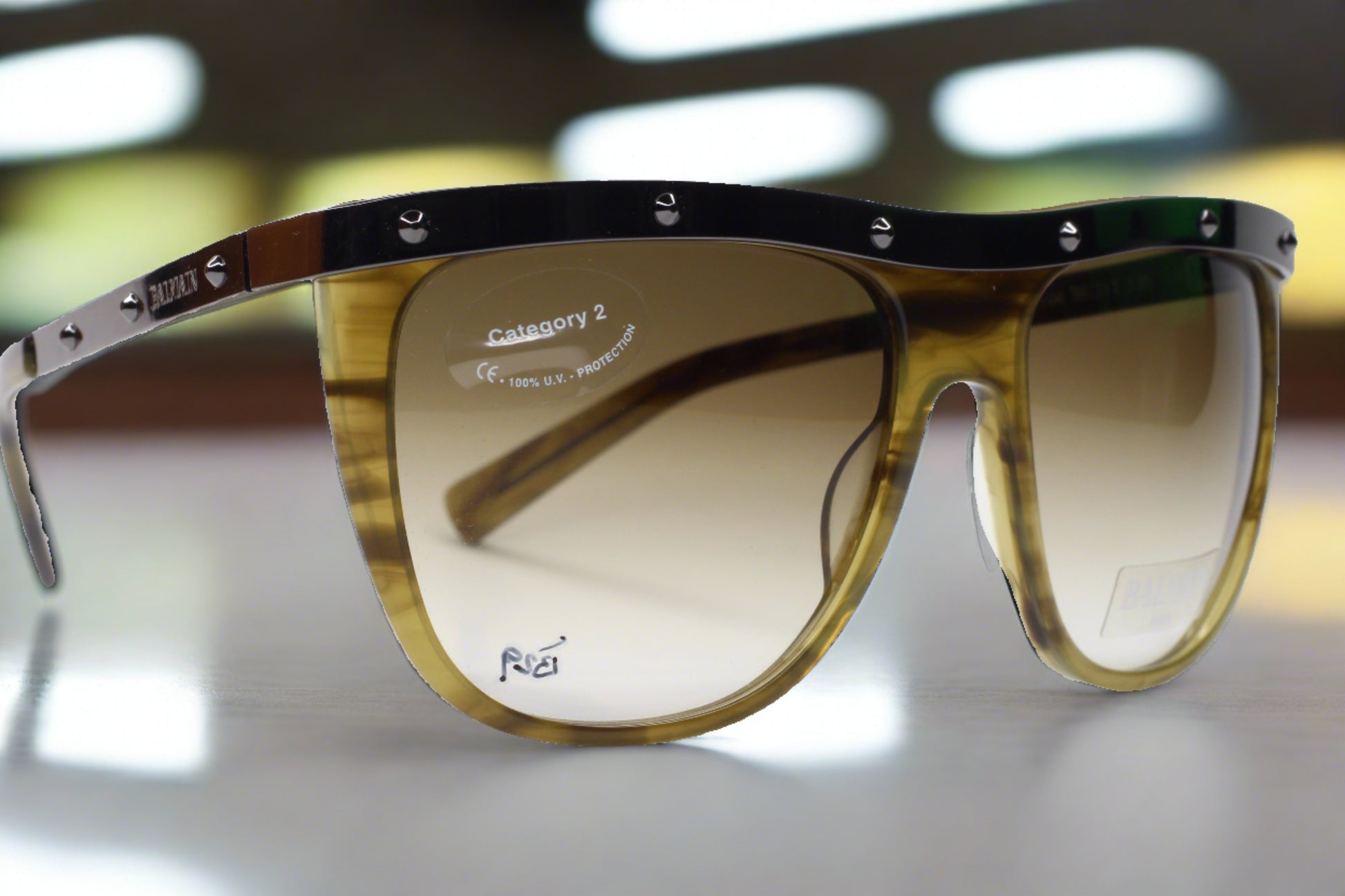 Balmain Paris khaki horn sunglasses with gradient lenses and studded top frame from ABC Optical