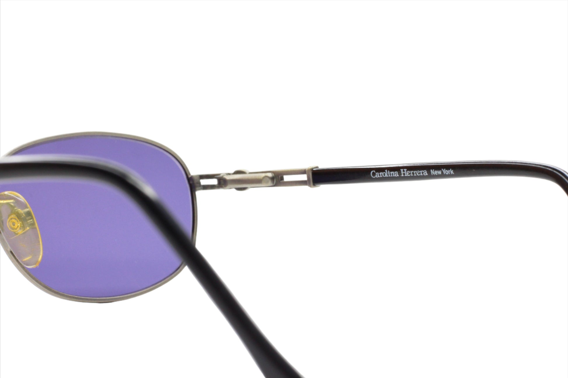 Close-up of CH804 PD520 Carolina Herrera sunglasses with purple lenses from ABC Optical