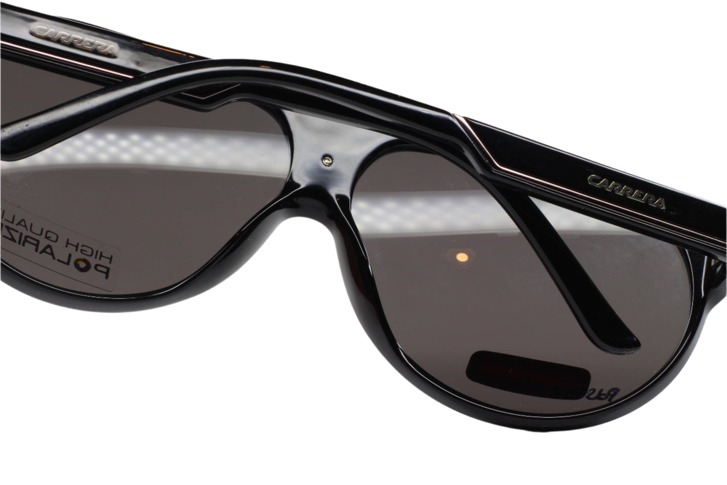 Close-up of Carrera 57 black aviator sunglasses with glossy frame and tinted lenses by ABC Optical