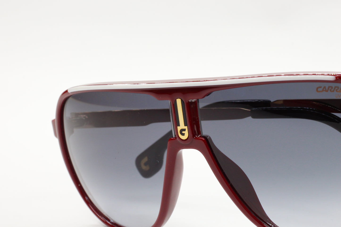 Close-up of aviator style Carrera sunglasses with dark tinted lenses and red frame by ABC Optical