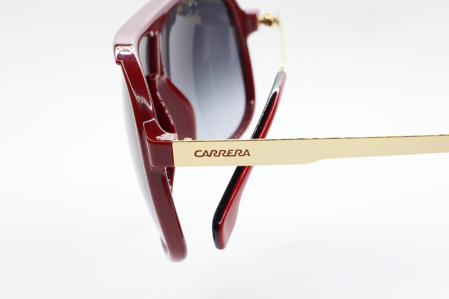 Close-up of aviator style Carrera sunglasses with gold temples and dark tinted lenses by ABC Optical