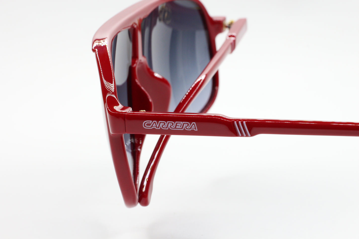 Close-up of red Carrera men's fashion eyewear optical frames by ABC Optical with logo on the temple