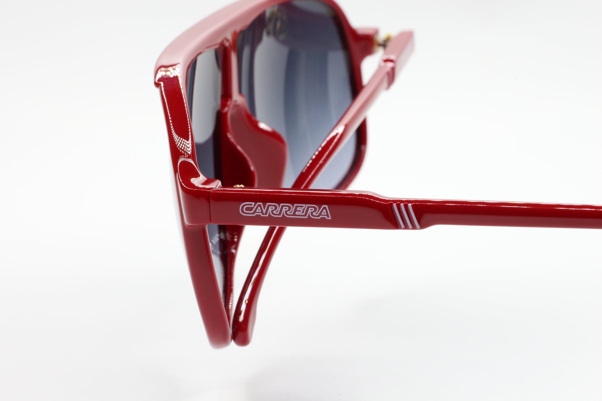 Close-up of red Carrera men's fashion eyewear optical frames by ABC Optical with logo on the temple