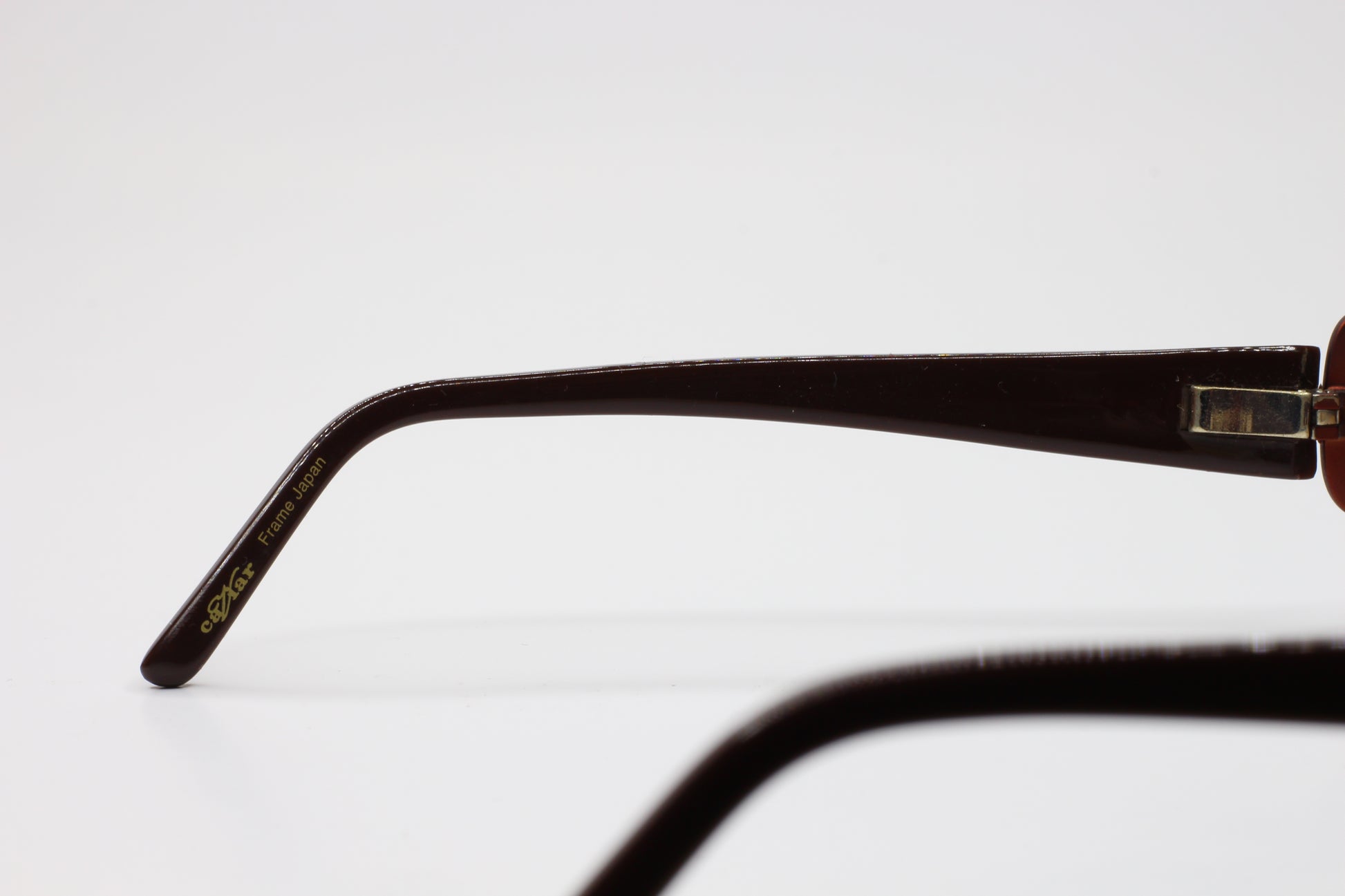 Close-up side view of Caviar M2608 gold brown sunglasses arm from ABC Optical