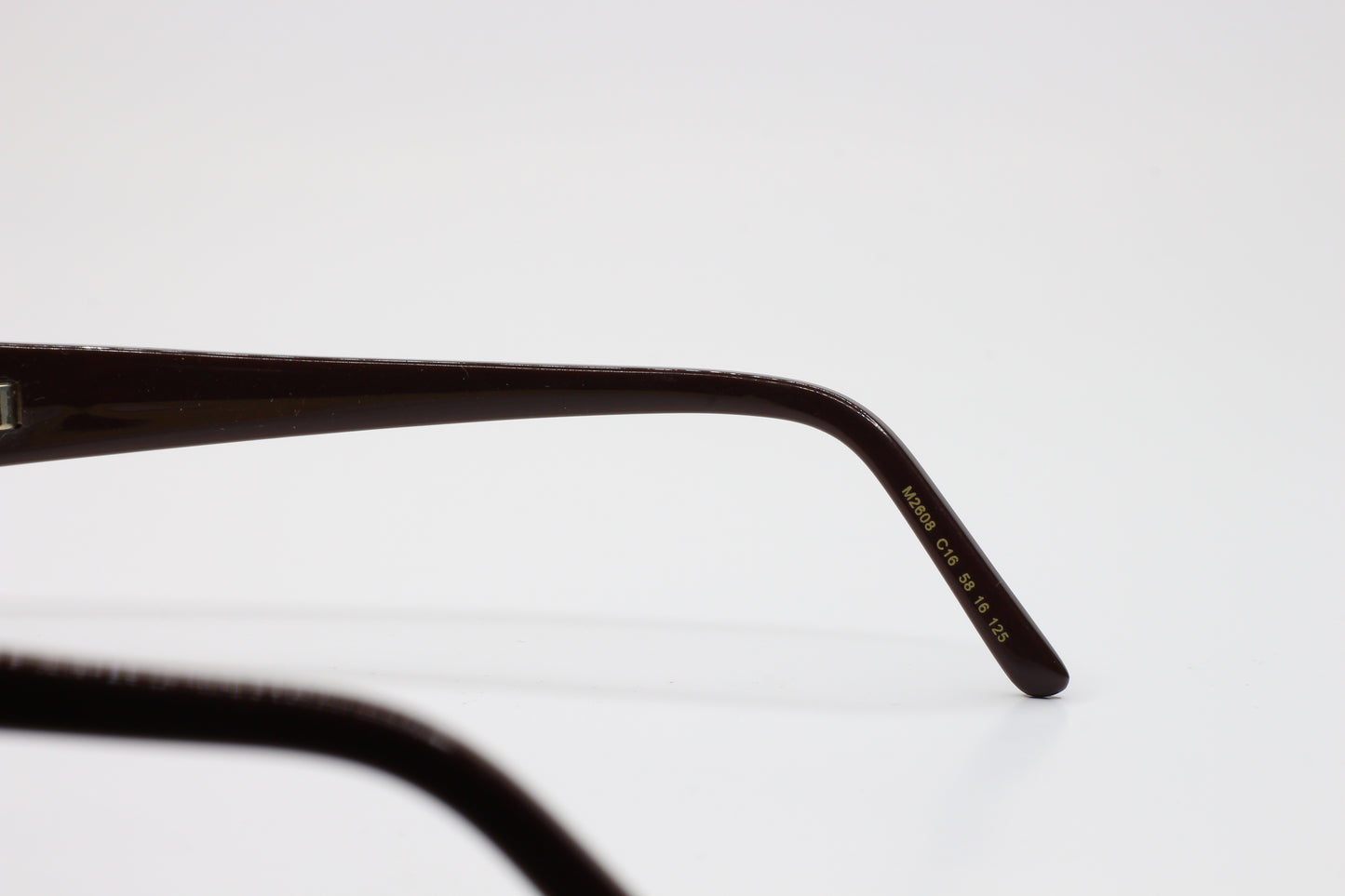 Close-up view of ABC Optical Caviar M2608 gold brown sunglasses temple arm with model details