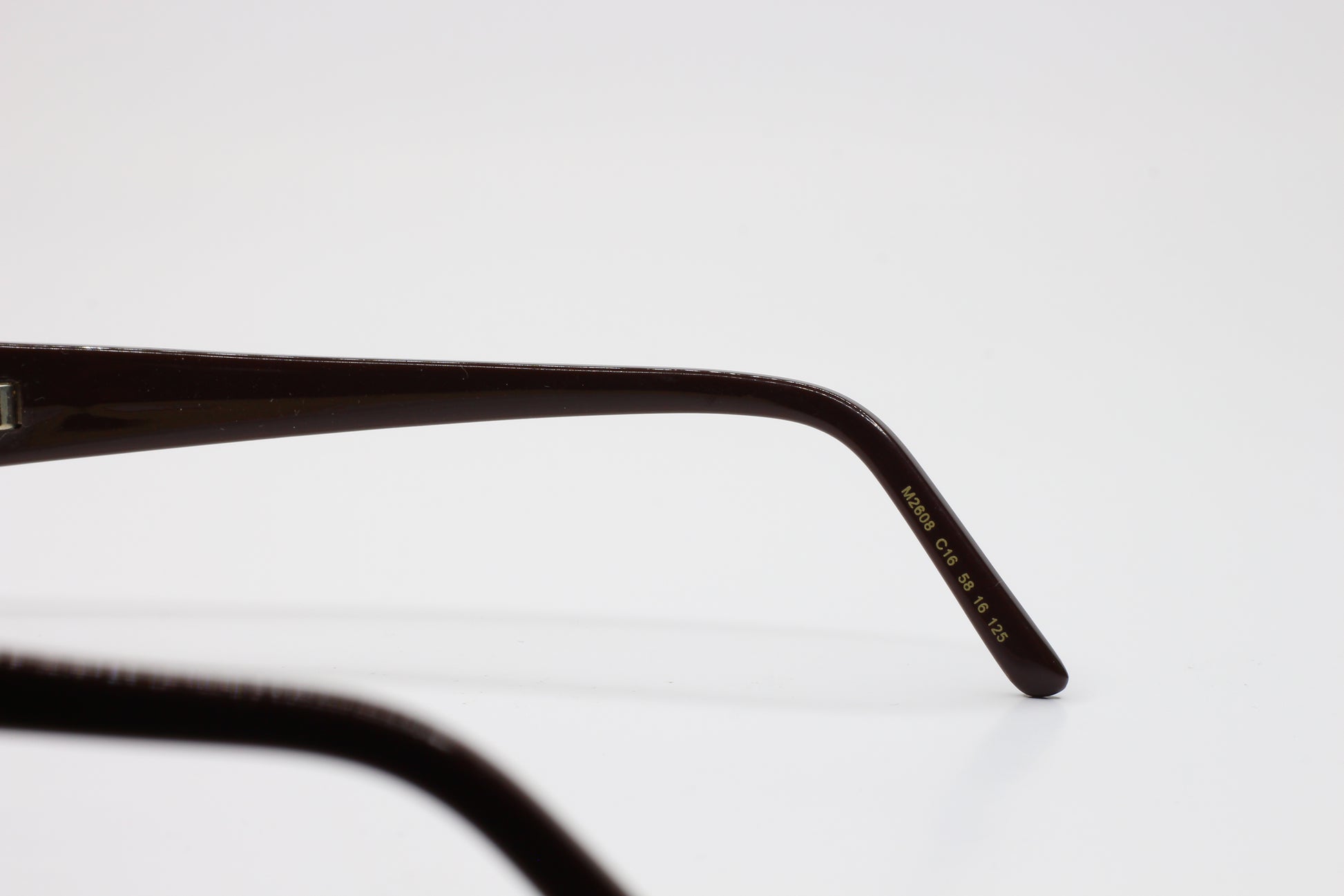 Close-up view of ABC Optical Caviar M2608 gold brown sunglasses temple arm with model details