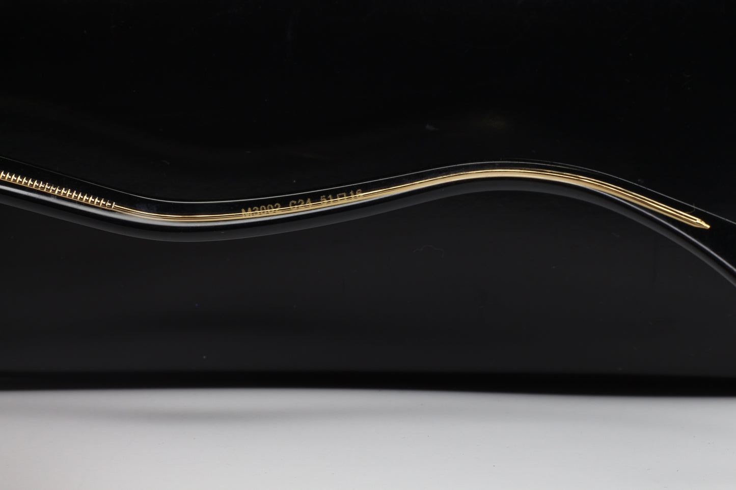 Close-up view of the gold and black frame arm of Caviar M3002 Swarovski sunglasses from ABC Optical