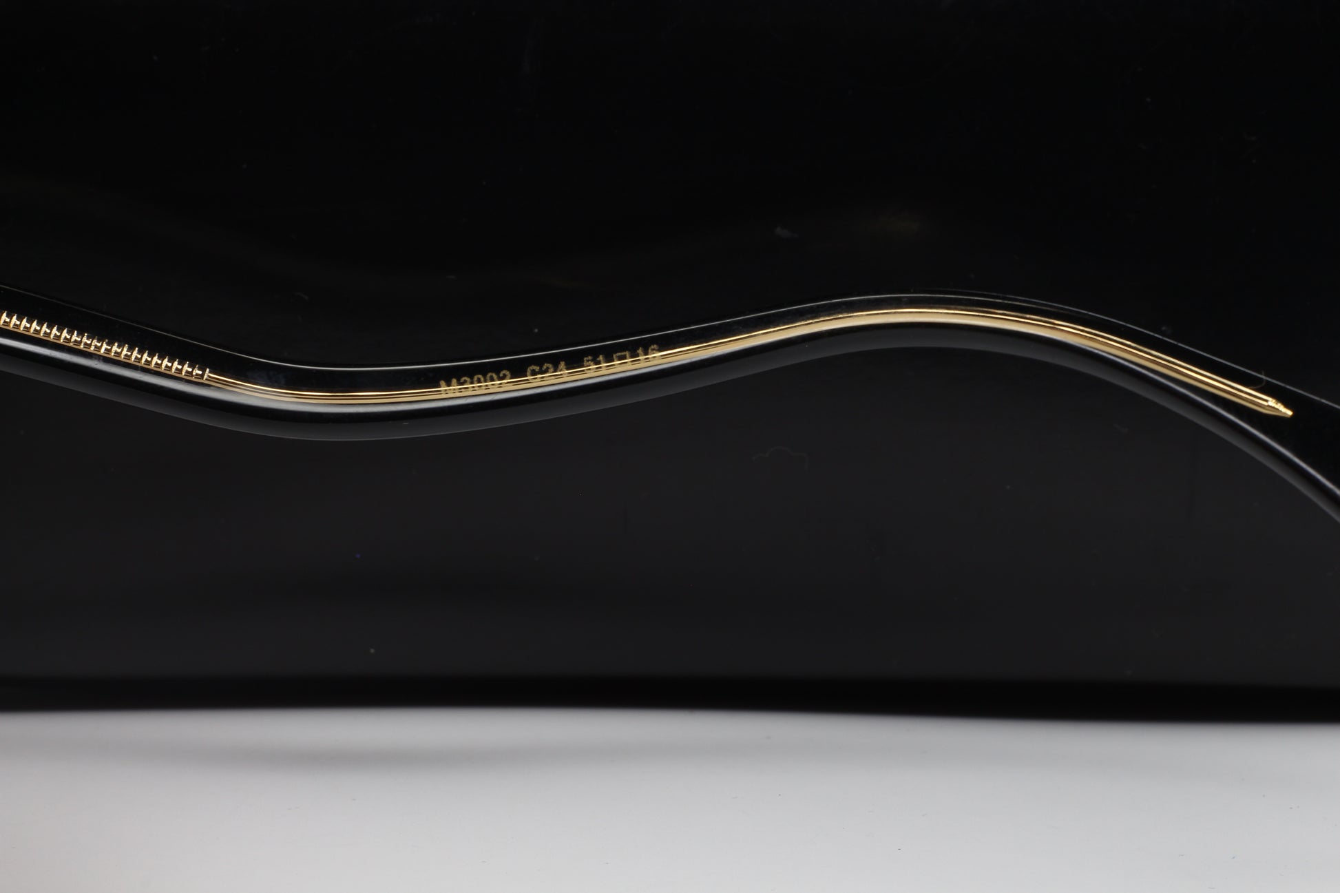 Close-up view of the gold and black frame arm of Caviar M3002 Swarovski sunglasses from ABC Optical