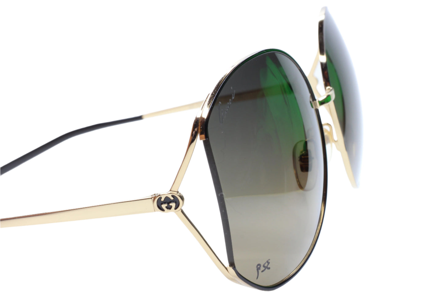 Gucci gold metal sunglasses women with green tinted lenses and black temple tips by ABC Optical