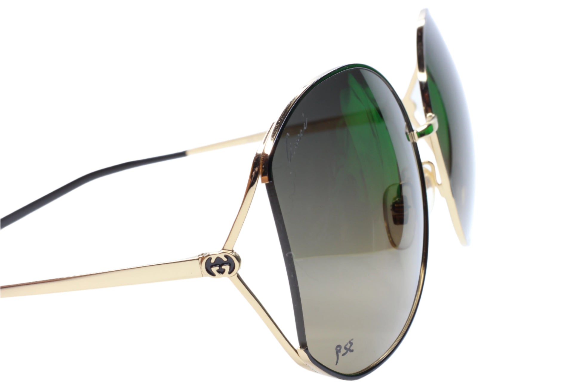 Gucci gold metal sunglasses women with green tinted lenses and black temple tips by ABC Optical