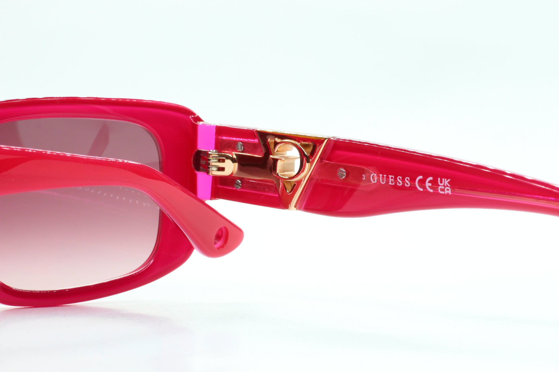 Guess pink gold sunglasses women by ABC Optical with stylish pink frames and gold accents