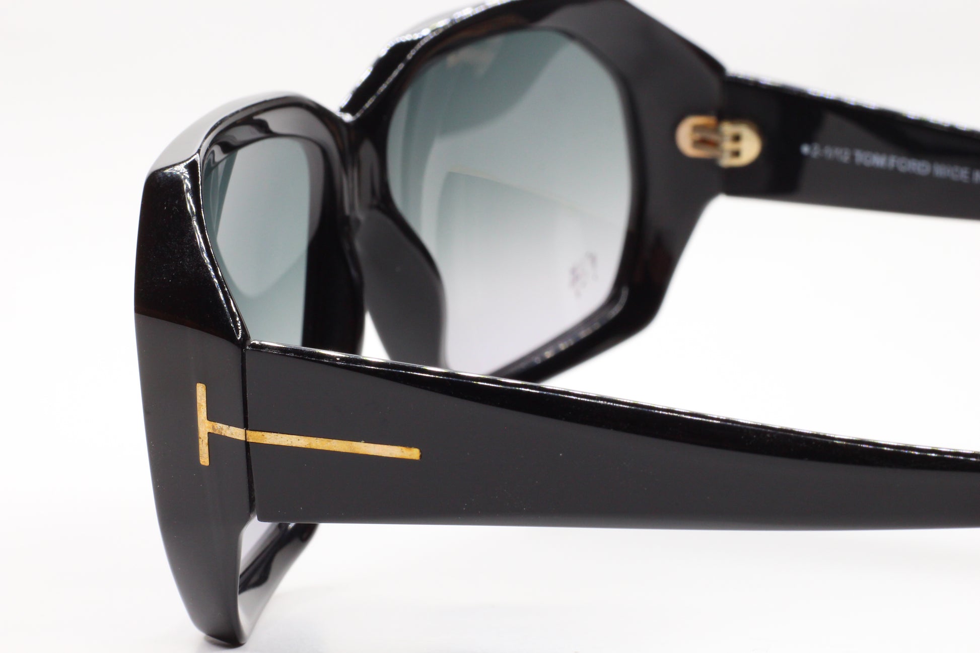 Close-up of black Tom Ford TF266 Elise sunglasses with gold logo detailing on the temples