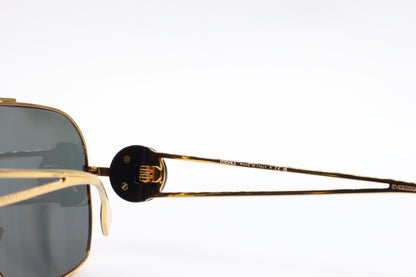 Close-up of ABC Optical luxury Italian designer sunglasses with gold metal frames and dark lenses