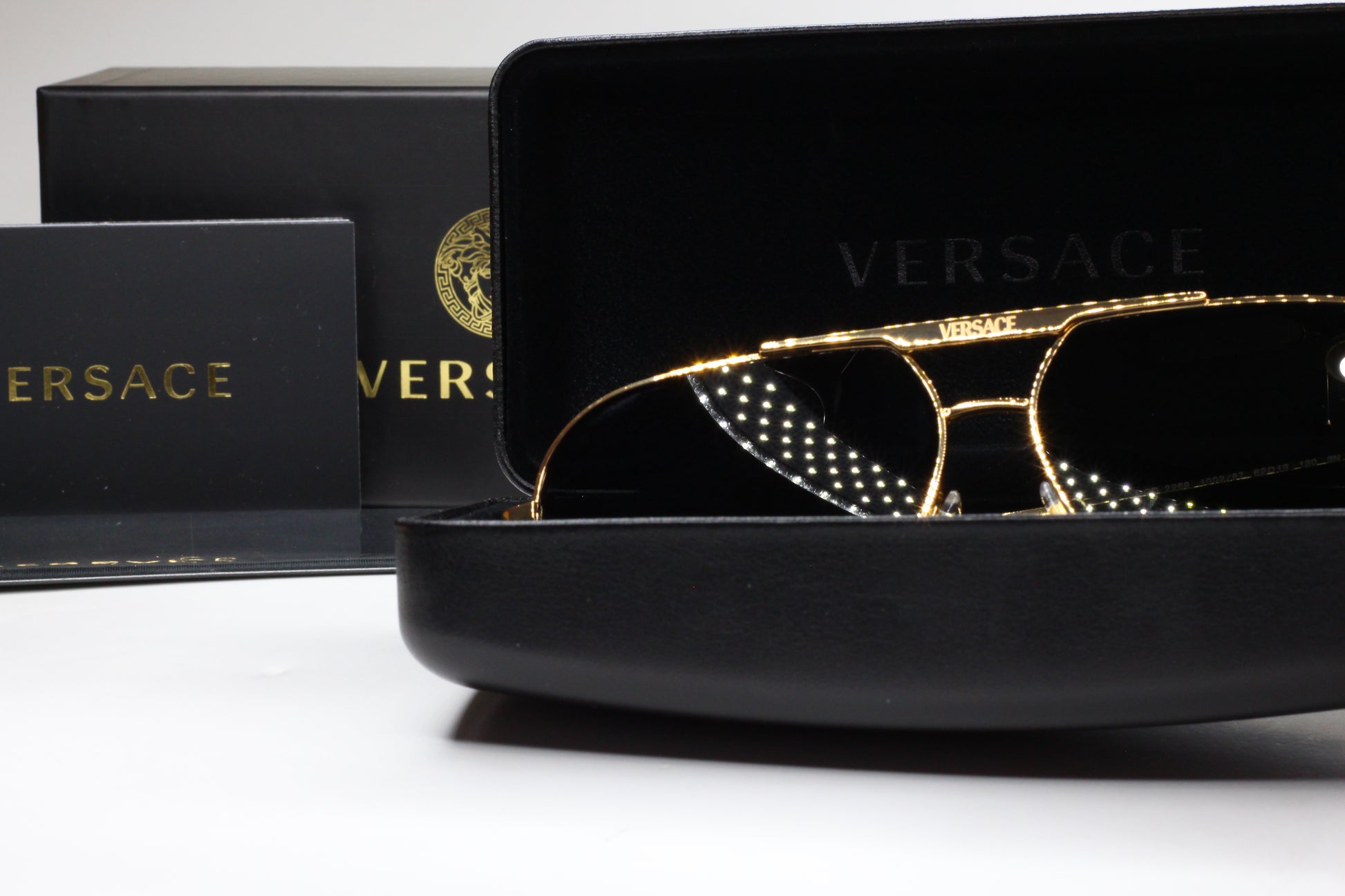 Luxury Italian designer sunglasses by ABC Optical in gold frame with Versace branding and black case